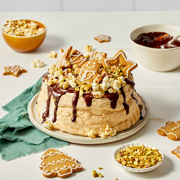 Party Pavlova with chocolate, caramel popcorn, pistachios and gignerbread biscuits